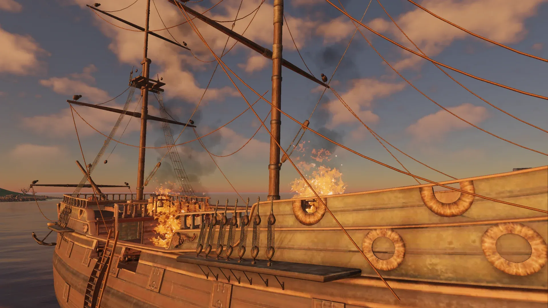 Flames and black smoke rise from a ship's deck beneath her rigging at sunset.